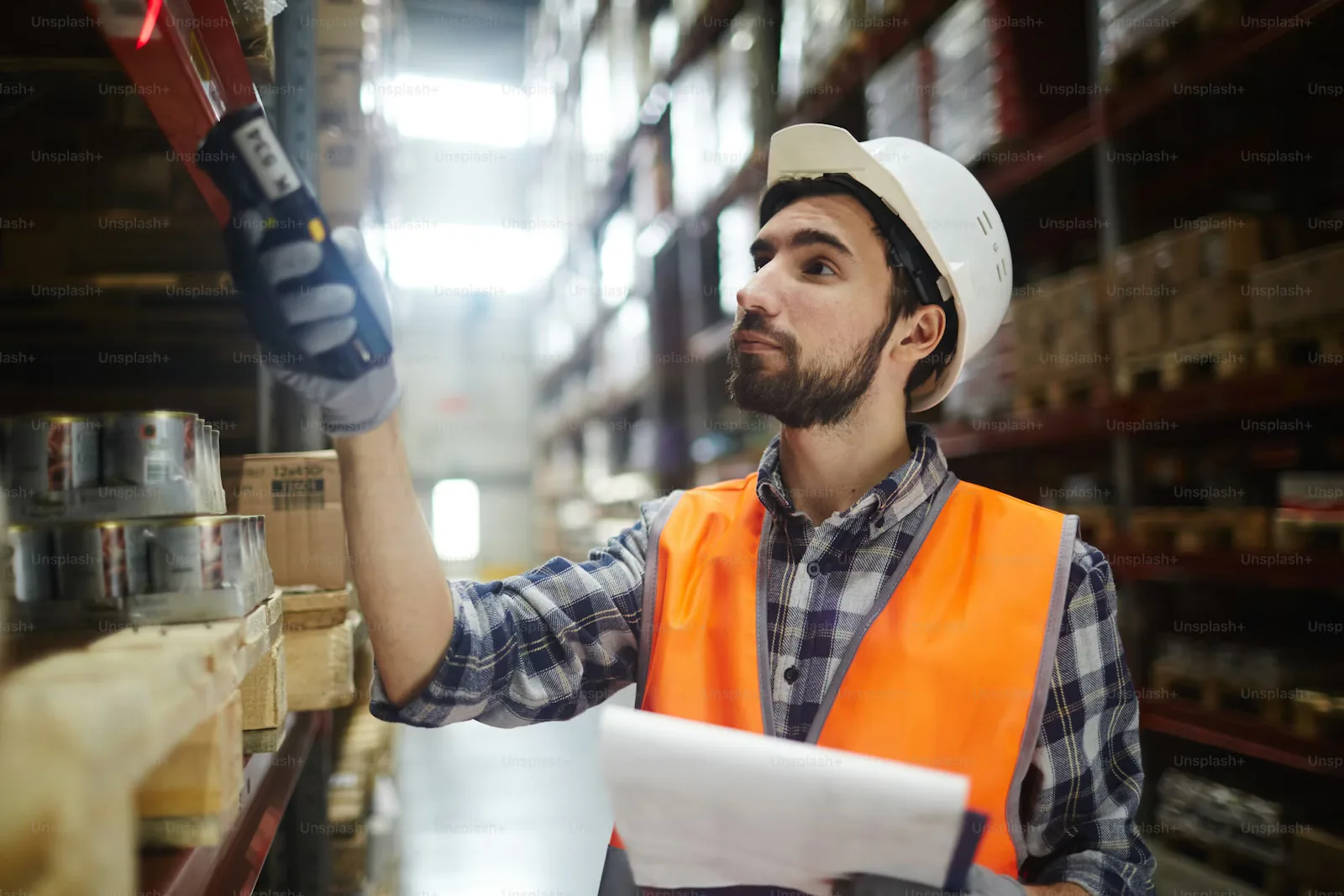 A logistics dispatcher scanning goods in a warehouse, representing dispatch execution and coordination.