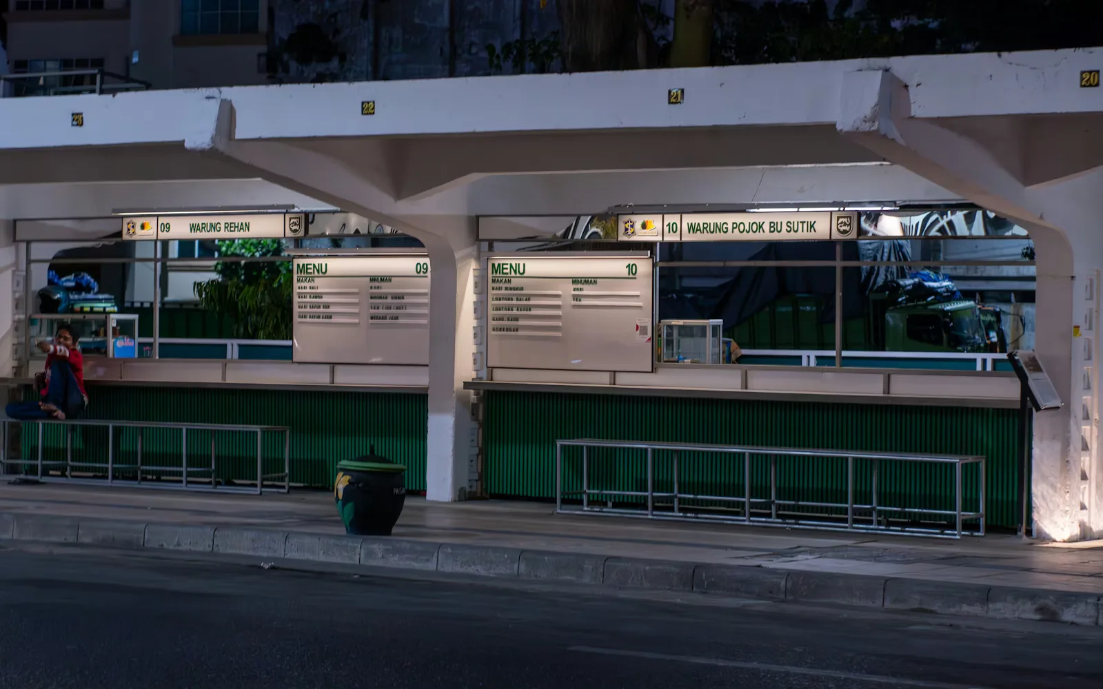 People waiting at a bus stop at night, representing peak-load event transport operations.